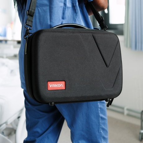 Nurse carrying the Vitascan eVue bladder scanner in the Vitacon Soft Carrying Case in a hospital setting